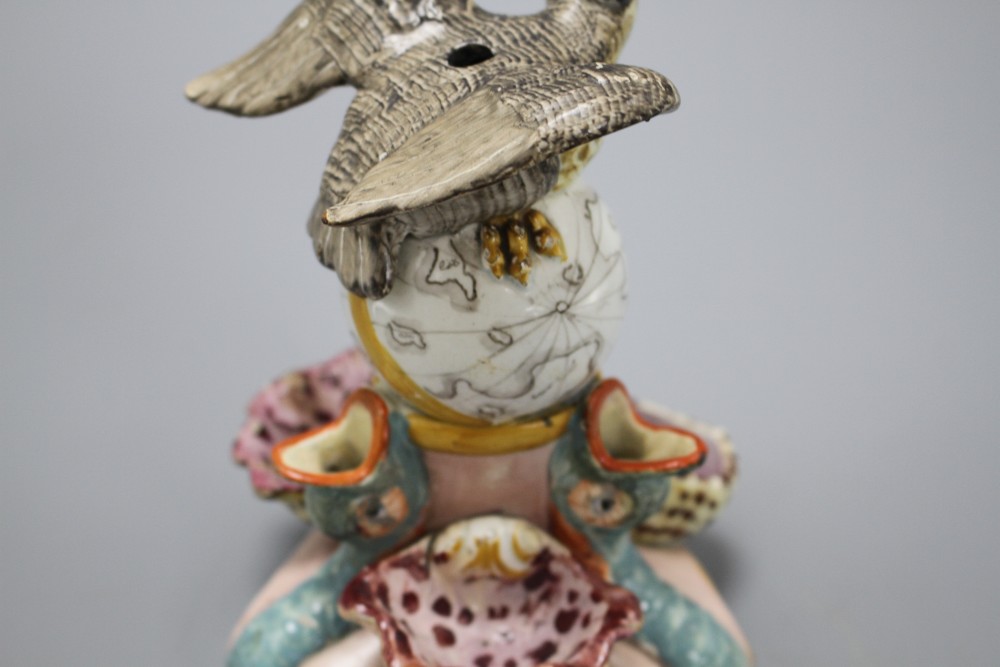 An early 19th century Staffordshire inkwell, modelled with an eagle perched upon a globe above three dolphins and shells, height 15cm